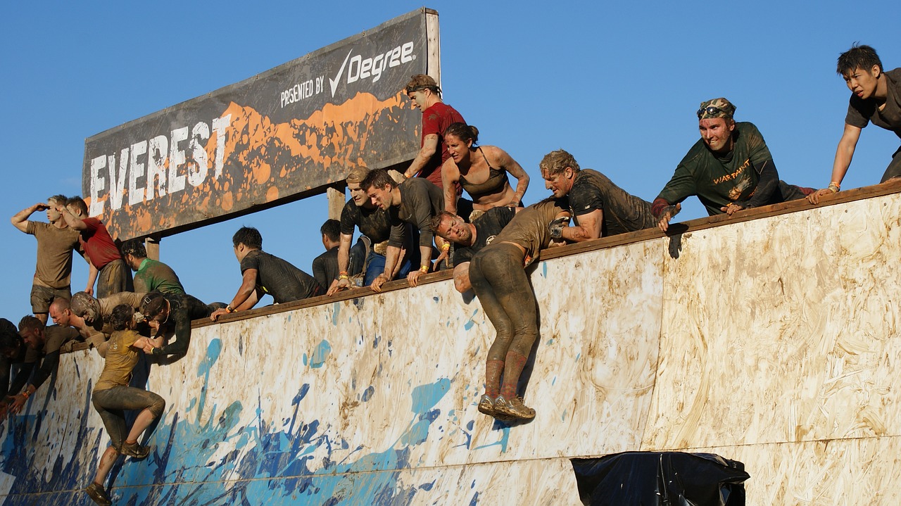 group of people on top of obstacle course wall